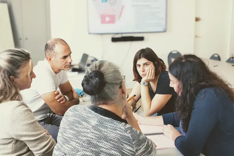 Un petit groupe de participants échange autour d'une table pendant une formation